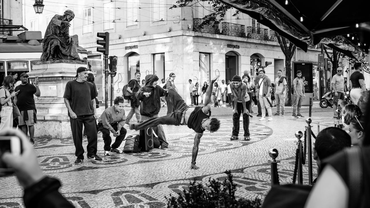 Black and white image of street performers in a lively urban scene.